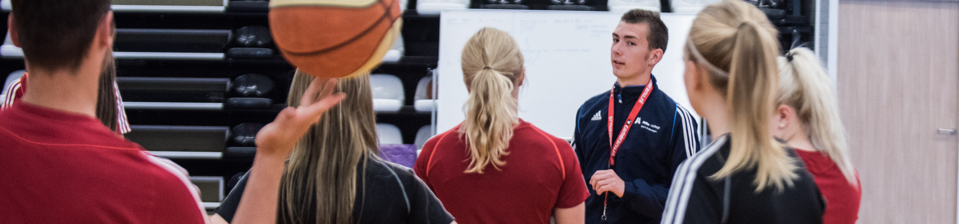 Sportstudenten luisteren naar docent in sportzaal